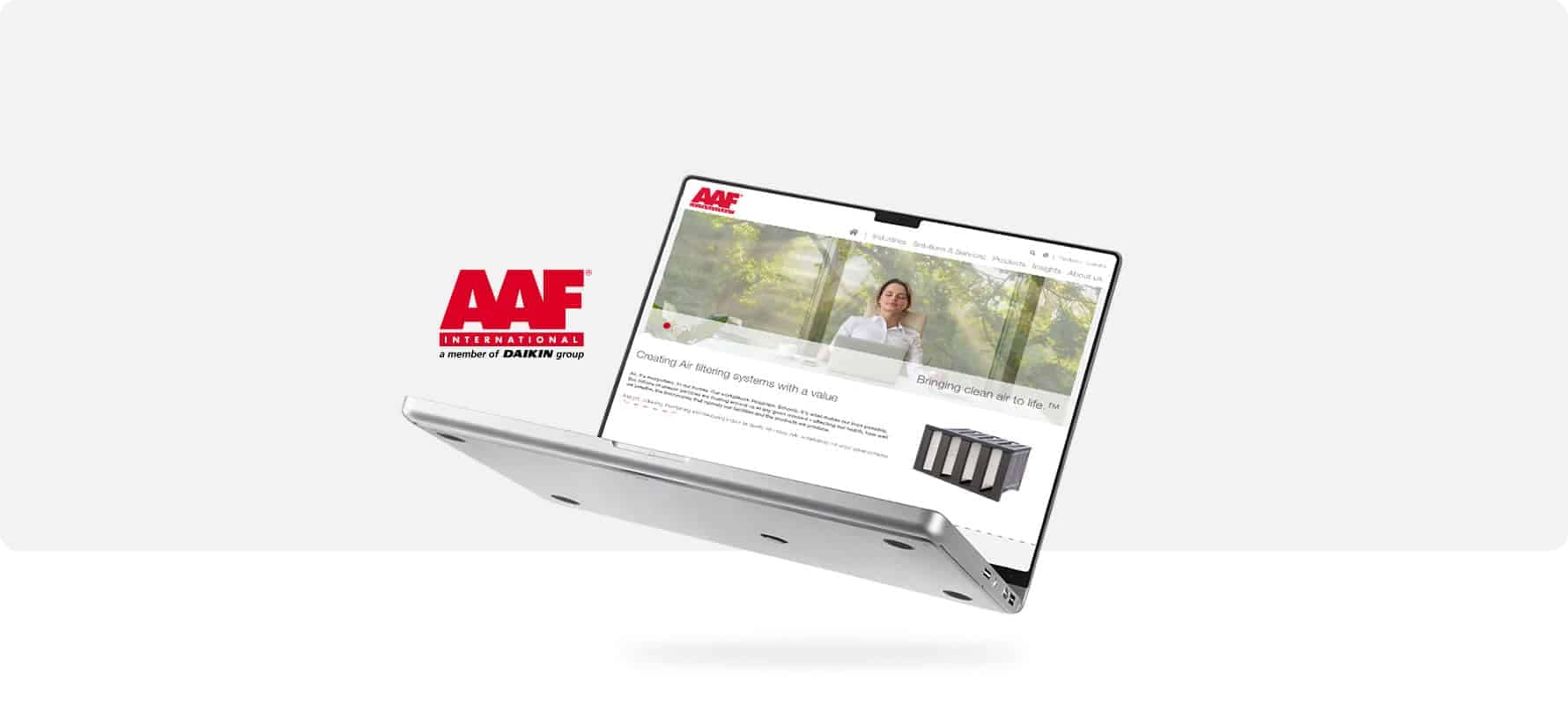 Silberner Laptop aus Metall mit geöffneter Webseite und rotem AAF International Logo